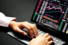 A focused entrepreneur working on a laptop with digital marketing graphs on screen.
