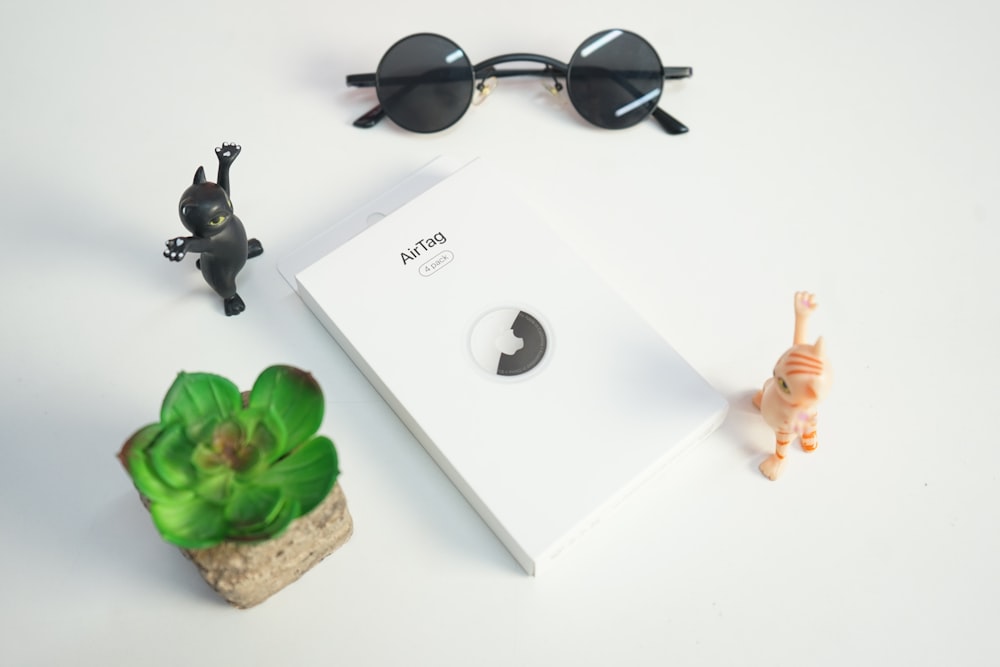 black framed sunglasses on white wooden table