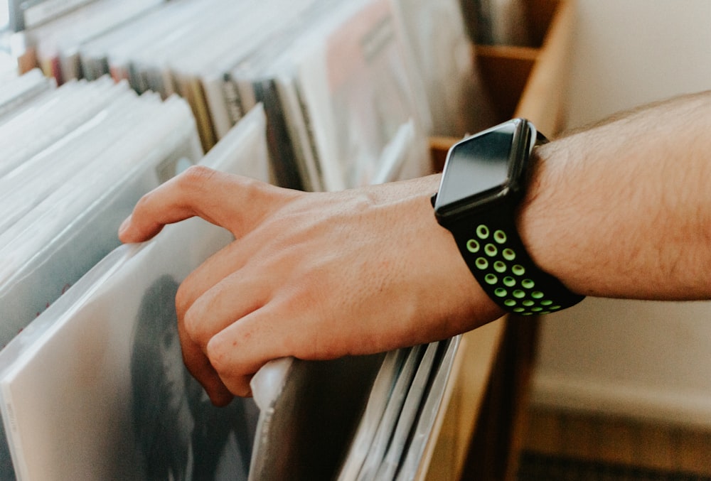 person wearing silver aluminum case apple watch with white sport band