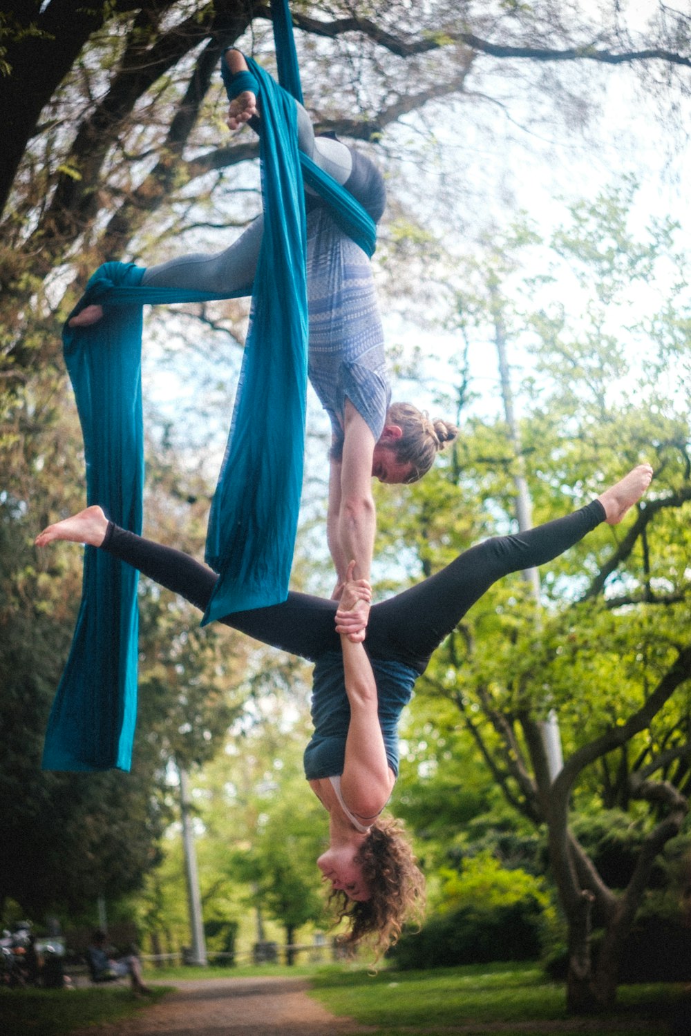 woman in blue and white long sleeve shirt and black leggings hanging on blue hammock