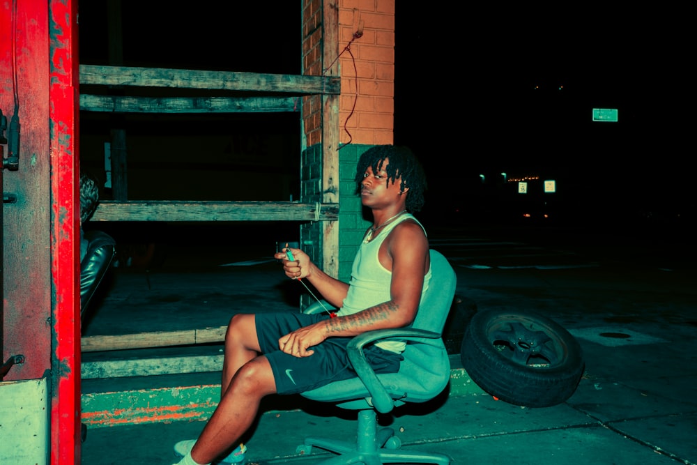 woman in white tank top sitting on green plastic chair