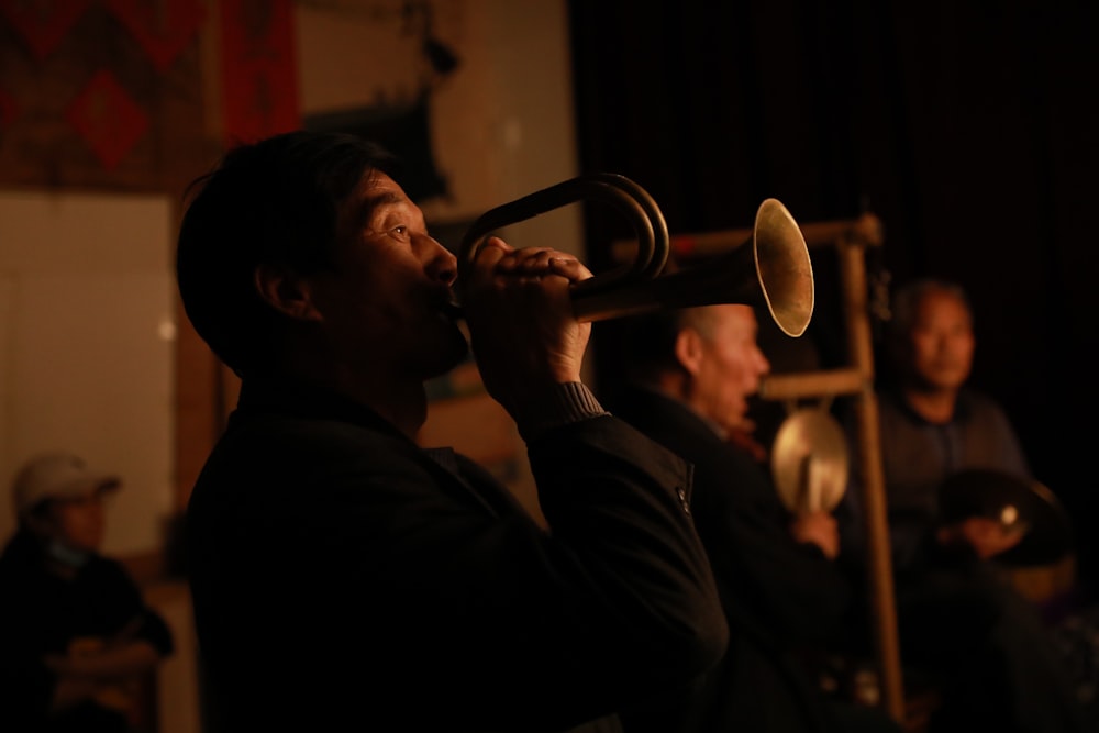 man in black long sleeve shirt playing trumpet