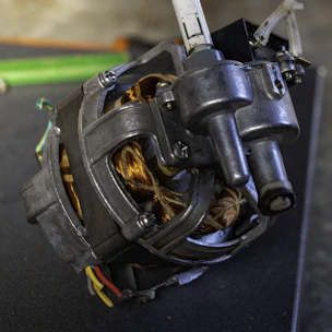 Close-up of a technician inspecting a custom-built transformer in a clean industrial workshop.