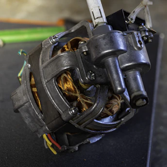 Close-up of a technician rewinding an industrial motor coil with precision tools.