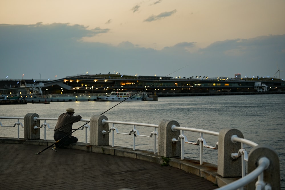 man in black jacket standing on dock during daytime