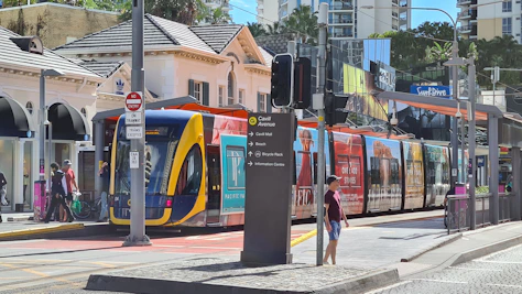 man in red jacket standing beside red and yellow train during daytime