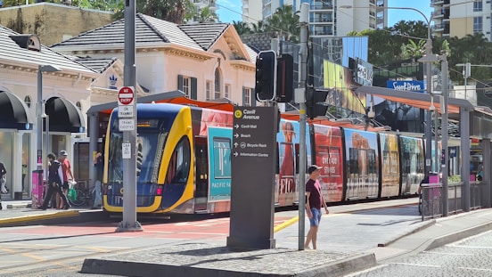 man in red jacket standing beside red and yellow train during daytime