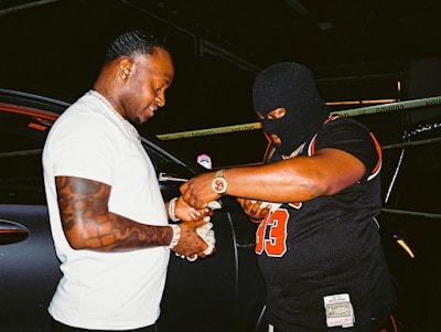 man in white crew neck t-shirt holding man in black t-shirt