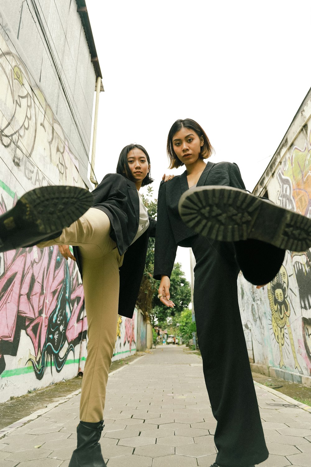 uomo in blazer nero in piedi accanto alla donna in sciarpa a pois in bianco e nero