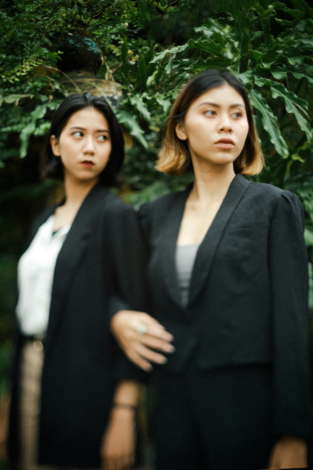 woman in black blazer standing near green leaf plant