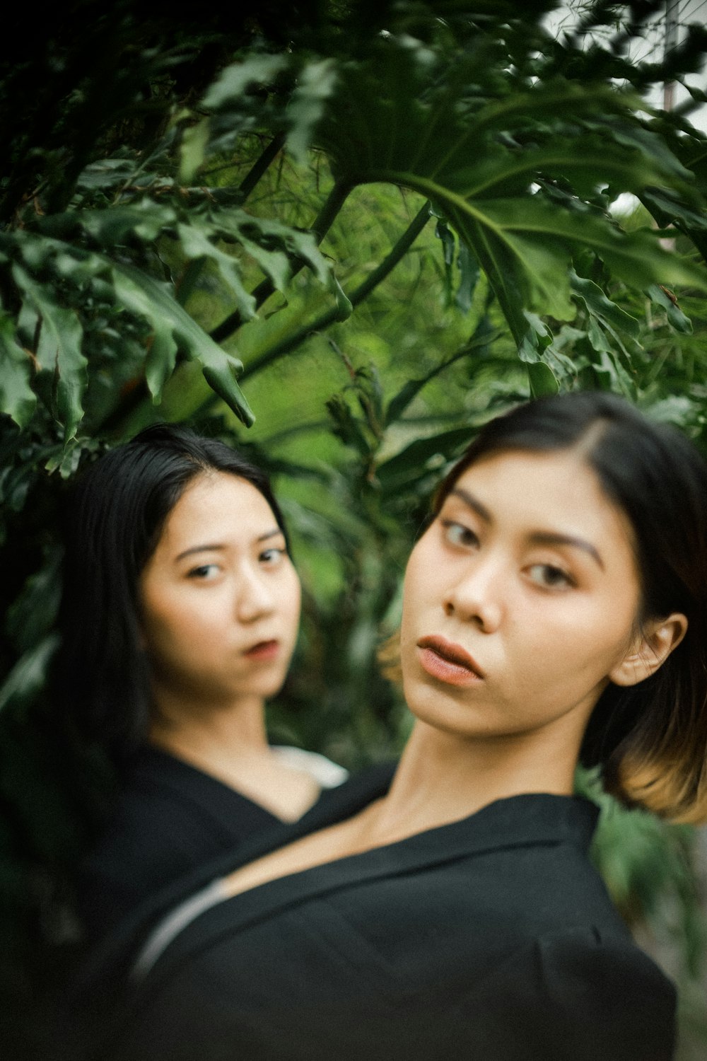 woman in black shirt standing beside green plant