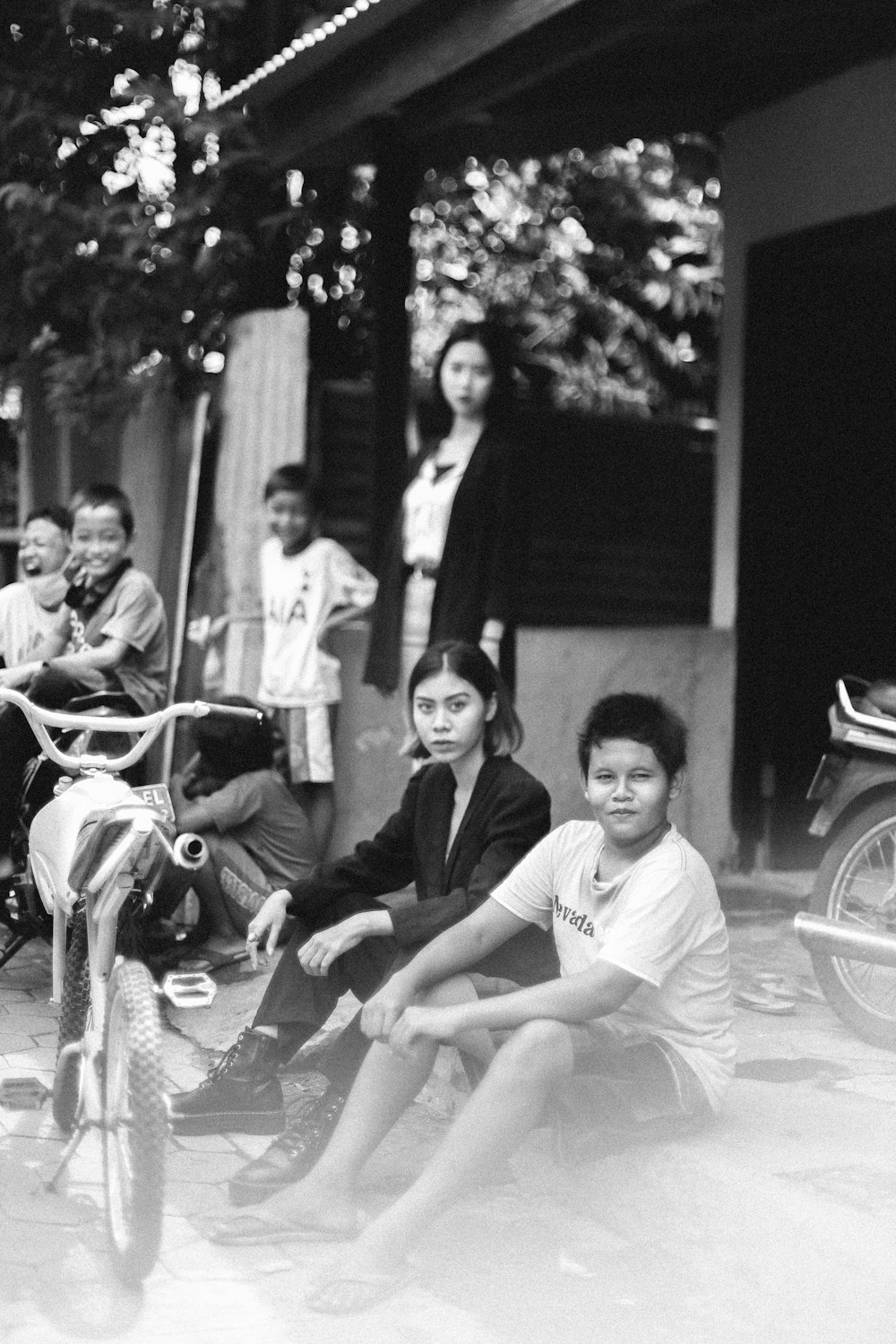 grayscale photo of 2 men sitting on motorcycle