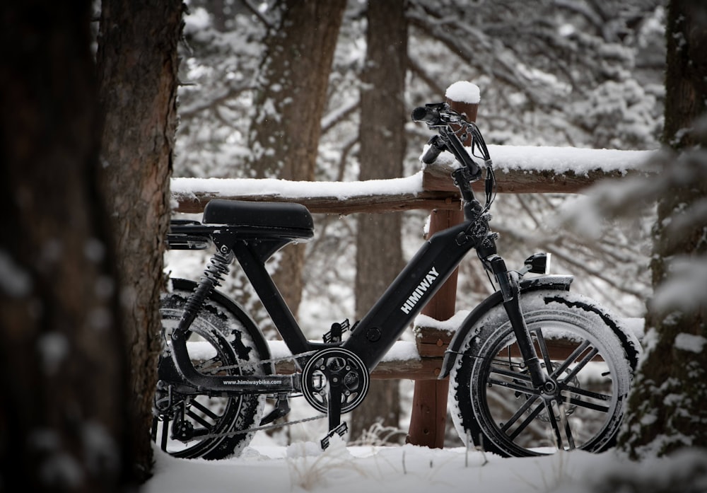 Bicicleta de montaña rígida negra y naranja en suelo cubierto de nieve