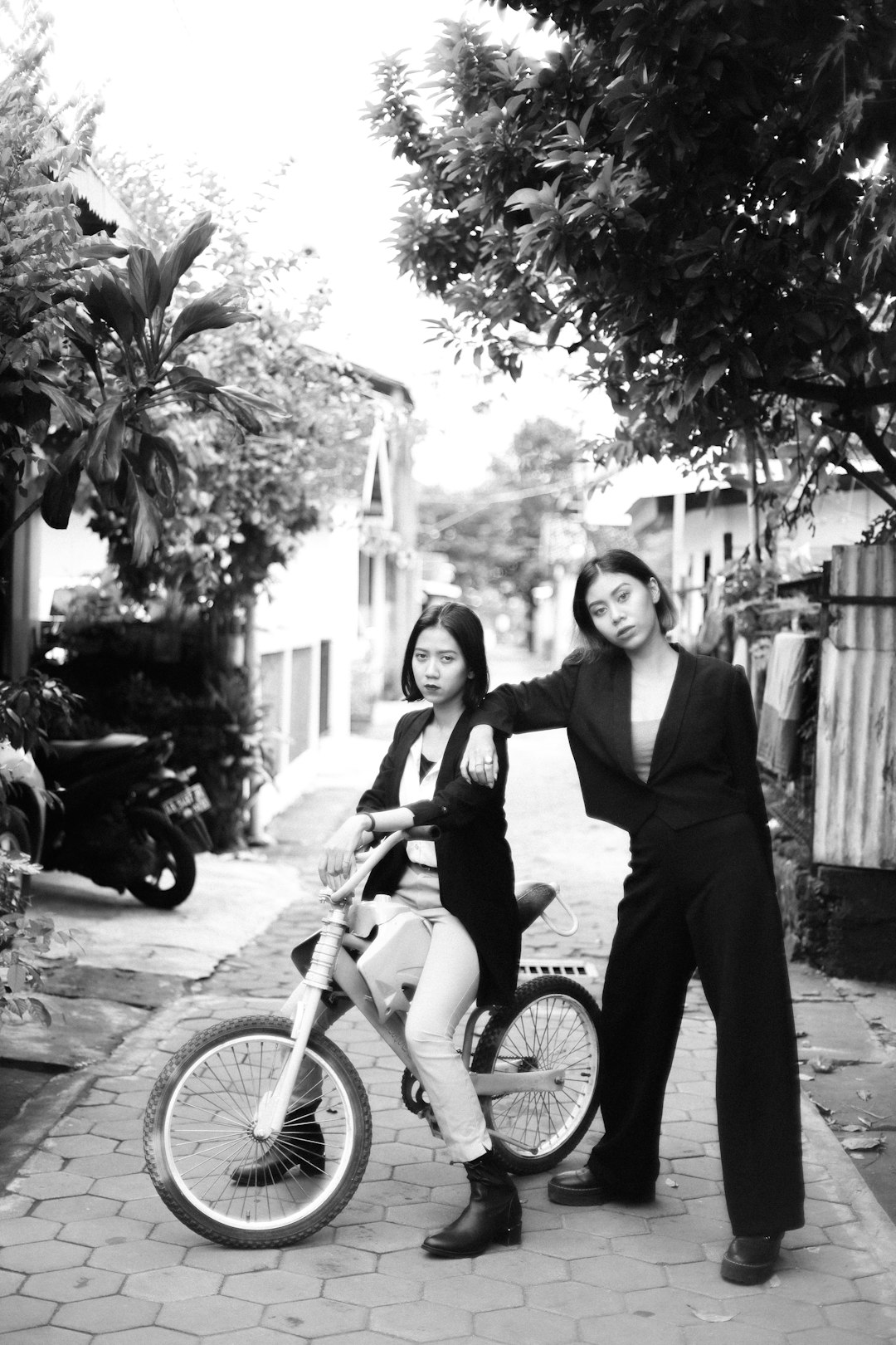 grayscale photo of 2 women riding on bicycle