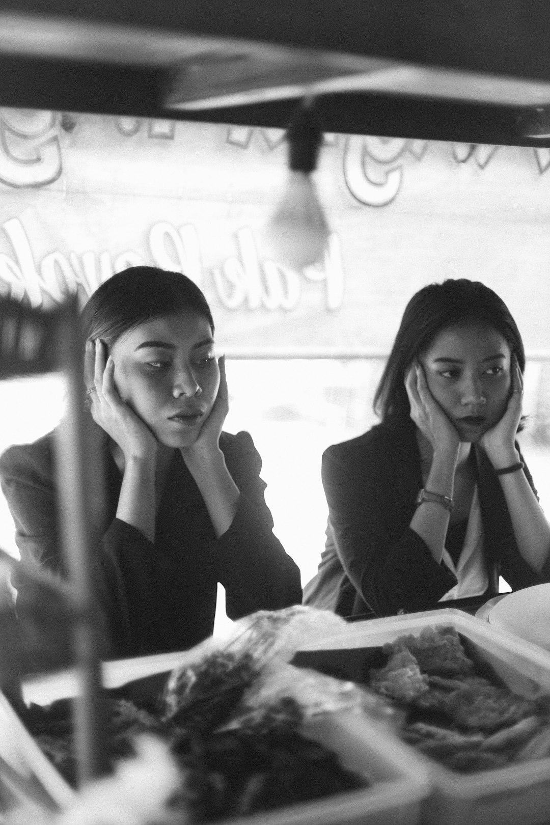 woman in black long sleeve shirt sitting beside woman in black long sleeve shirt