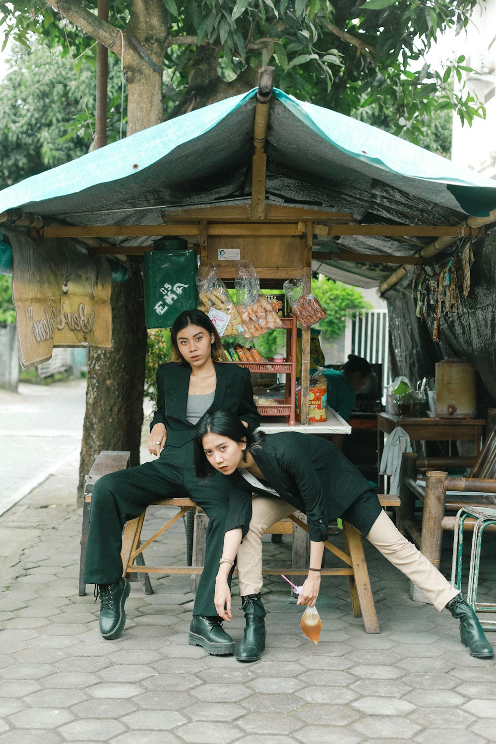 a couple of women sitting on top of a wooden bench