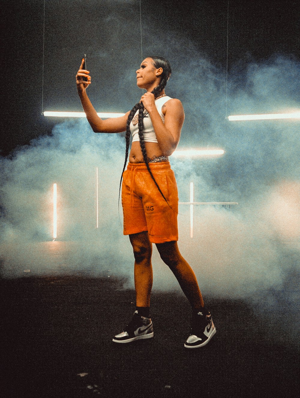 woman in orange sleeveless dress and black nike shoes