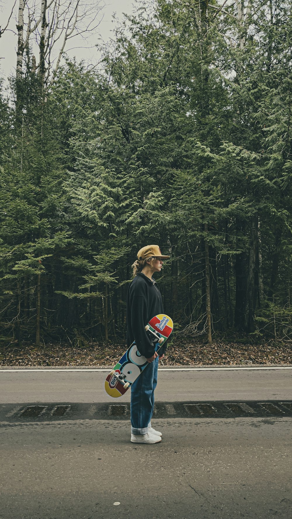 Mann in schwarzer Jacke und blauer Jeans fährt tagsüber Skateboard auf der Straße
