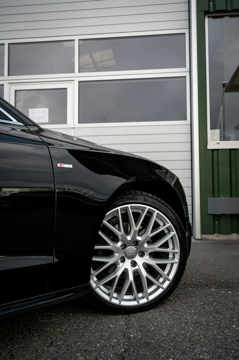 black car parked in front of white wooden house