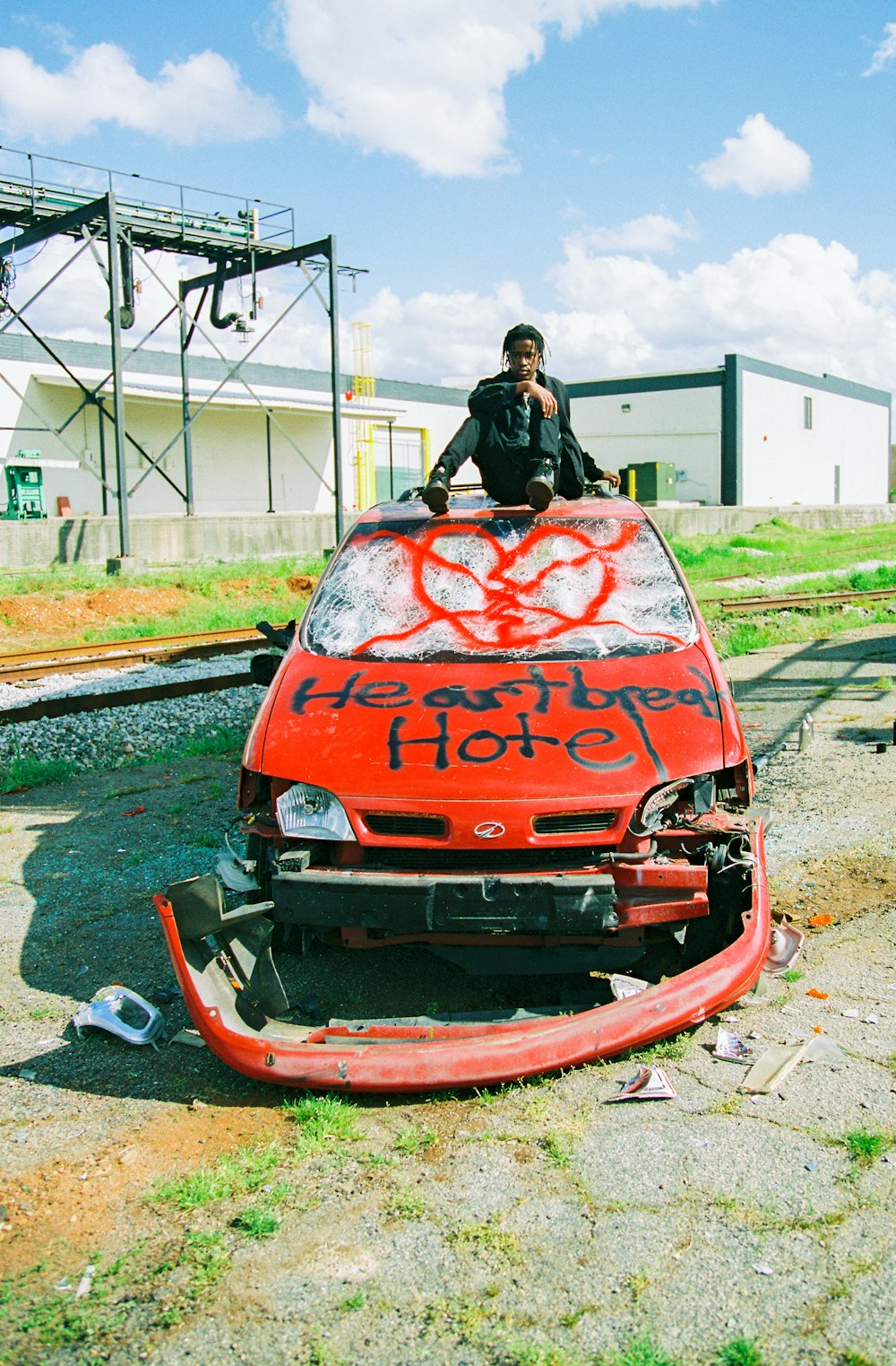 man in black jacket riding red and black car