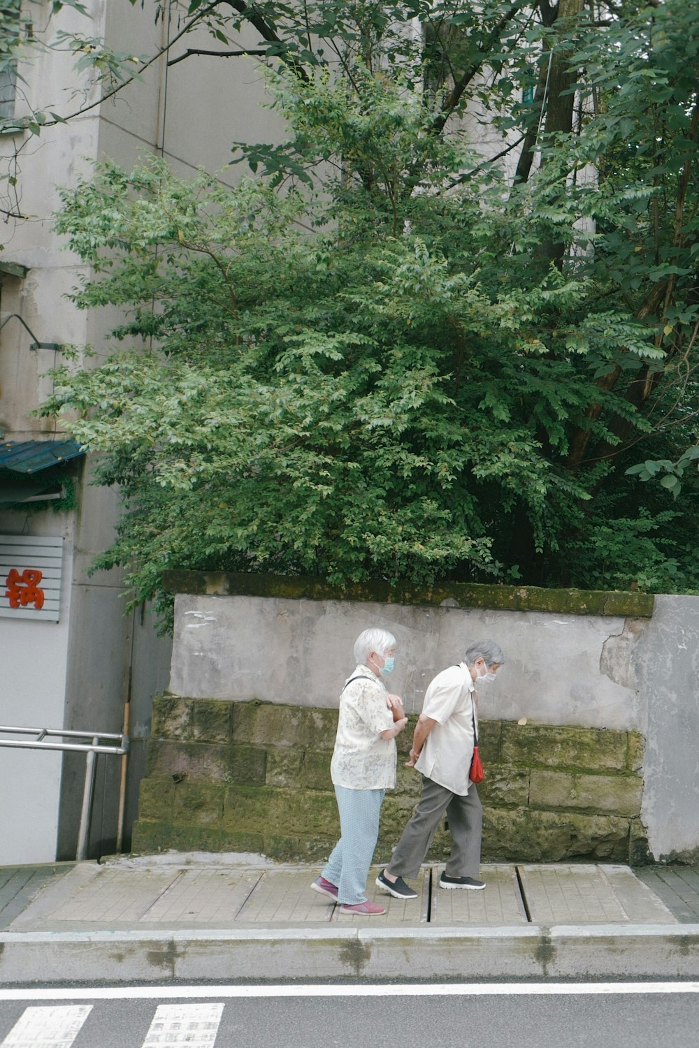 Uomo in thobe bianco che si leva in piedi vicino agli alberi verdi durante il giorno