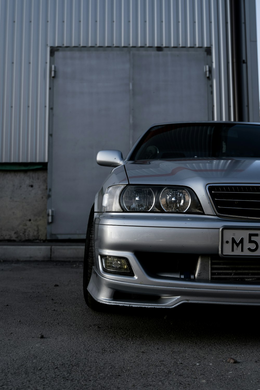 black mercedes benz car parked beside gray roll up door