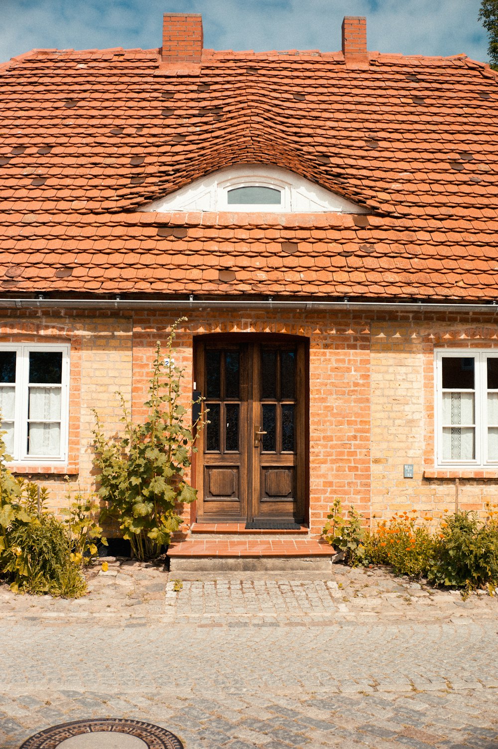 brown brick house with green plants