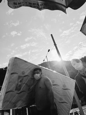 Two movers carrying a large mattress down a staircase with teamwork and care.
