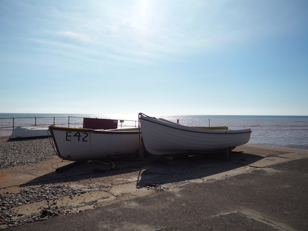 white and red boat on beach during daytime