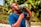 Man enjoying a refreshing drink of alkaline natural mineral water outdoors near a park.