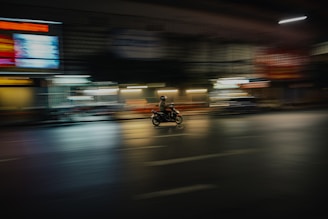 Driver on a motorcycle navigating city streets swiftly.