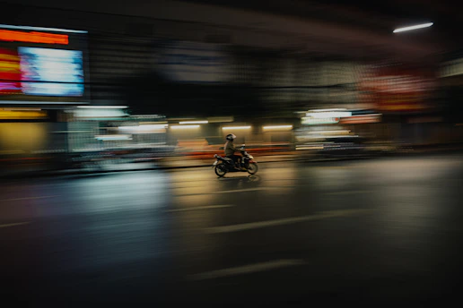 A sleek motorbike courier speeding through city streets at dusk.