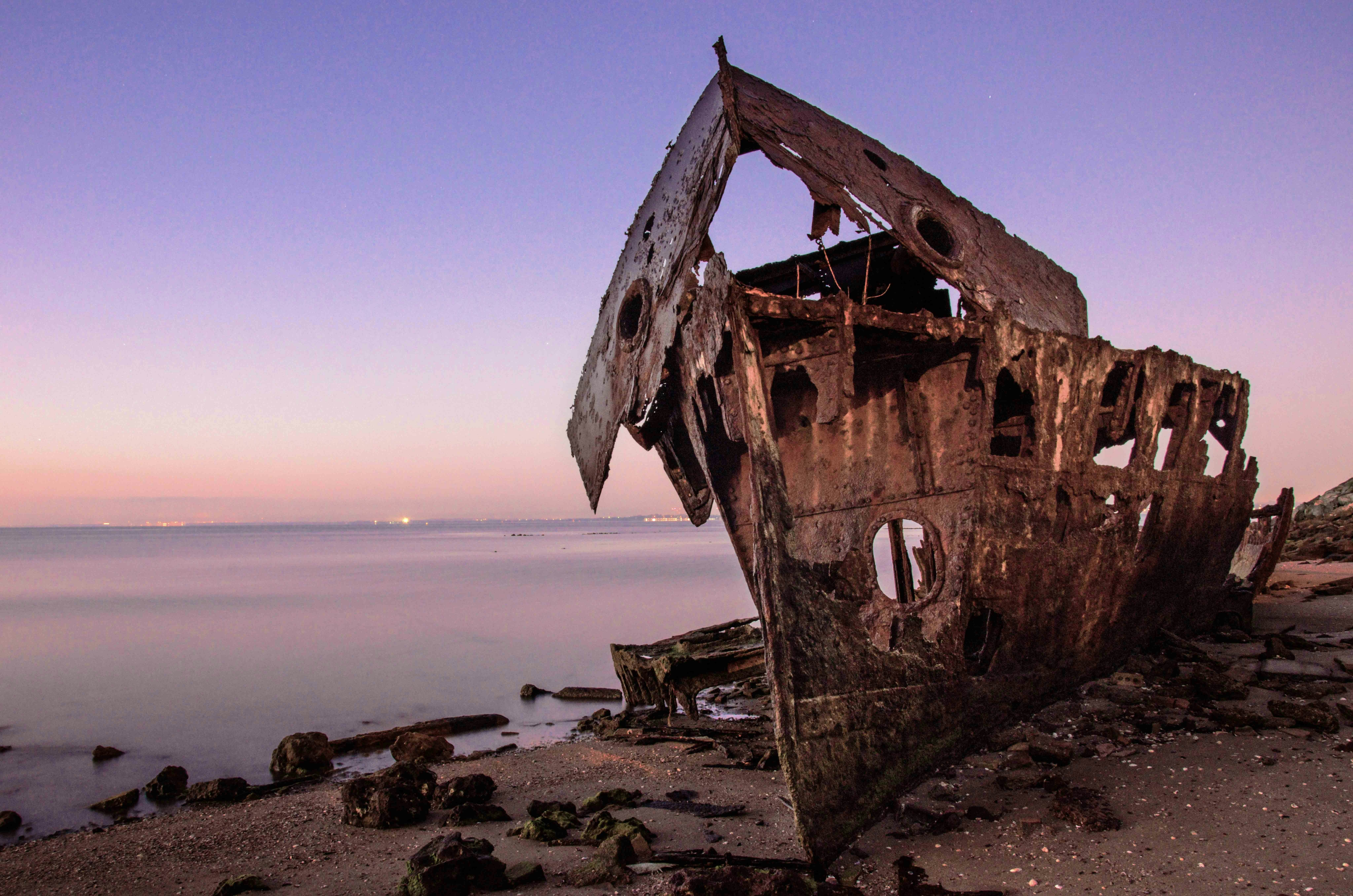 brown wooden ship on sea shore during daytime, A long exposure shot of a rusty boat just before dawn.</p><p>HMQS Gayundah was a gunboat operated by the Royal Australian Navy, entering service in 1884; and eventually run aground in 1958 in Brisbane to serve as a breakwater structure.</p><p>This shot was taken in 2018. It has deteriorated significantly since then.