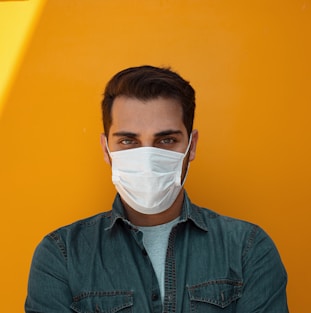 man in white face mask and green button up shirt