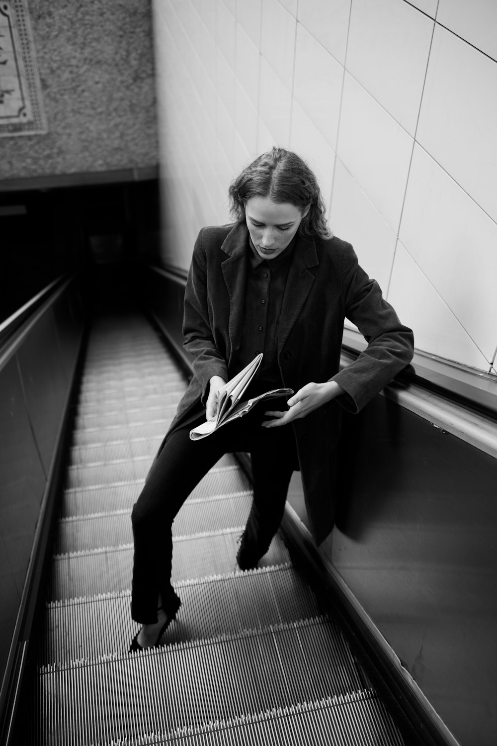 woman in black coat sitting on staircase