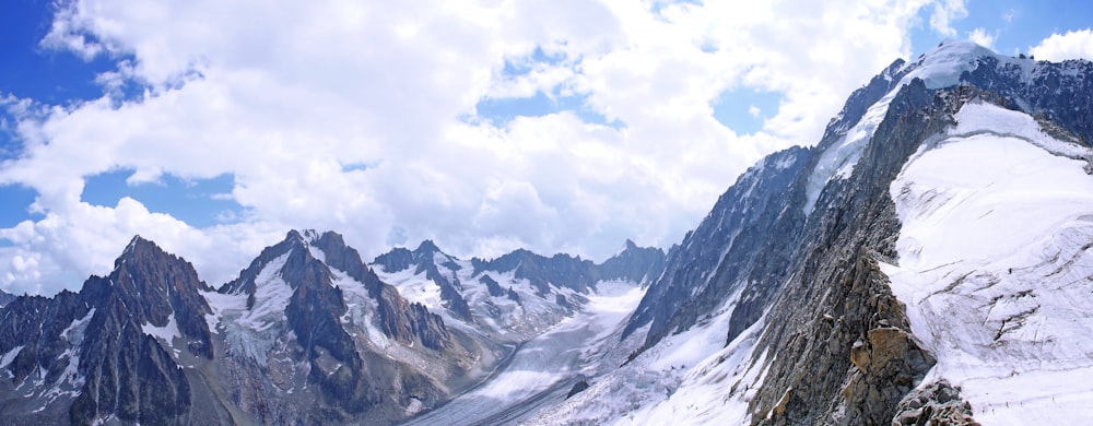 Schneebedeckte Berge tagsüber unter weißen Wolken