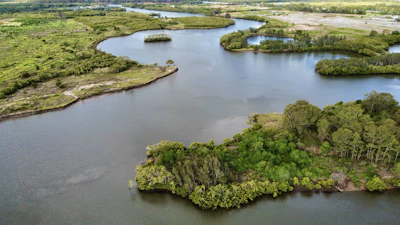 An aerial shot captured by a drone showing a winding river and lush greenery.