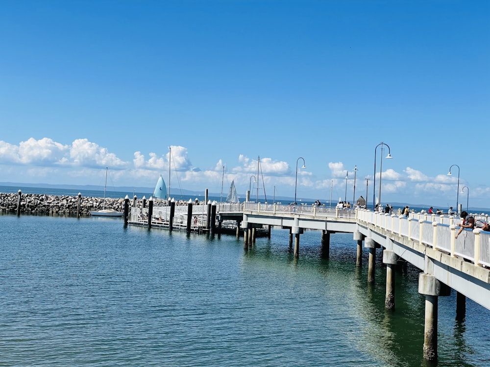 white wooden dock on sea under blue sky during daytime