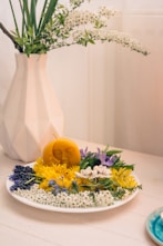 yellow and white flowers in white ceramic vase