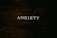 A dark wooden textured background with the word 'ANXIETY' in white capital letters centered prominently.