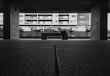 High contrast black and white image of an urban plaza with minimalist benches and clean paving.