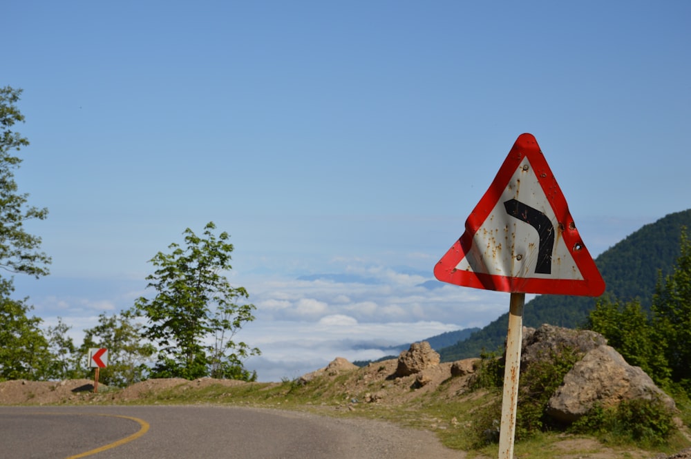 red and white stop sign on gray asphalt road under blue sky during daytime