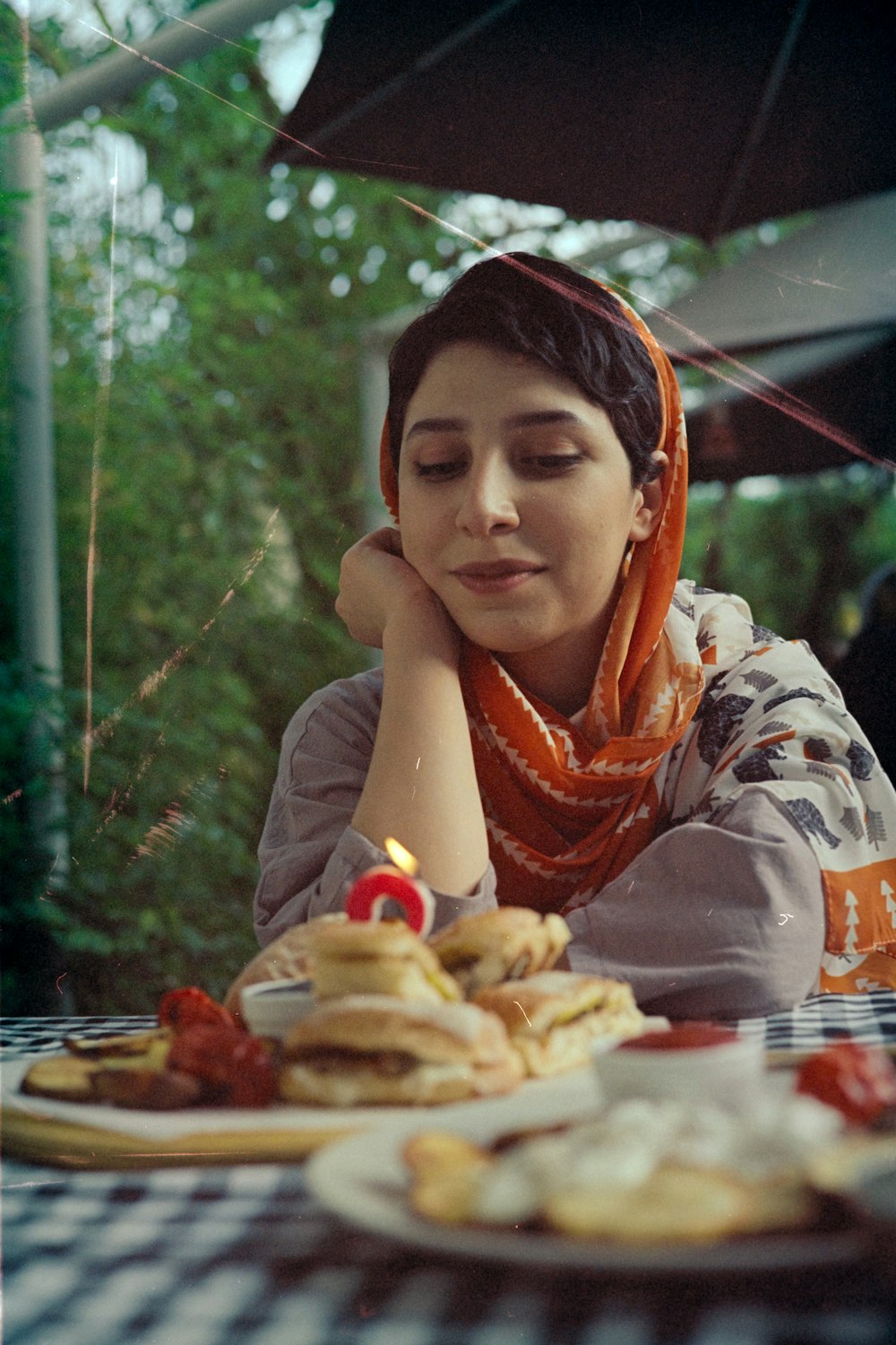 woman in white and brown long sleeve shirt eating burger