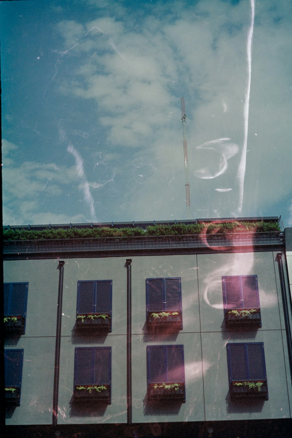 brown and black concrete building under blue sky and white clouds