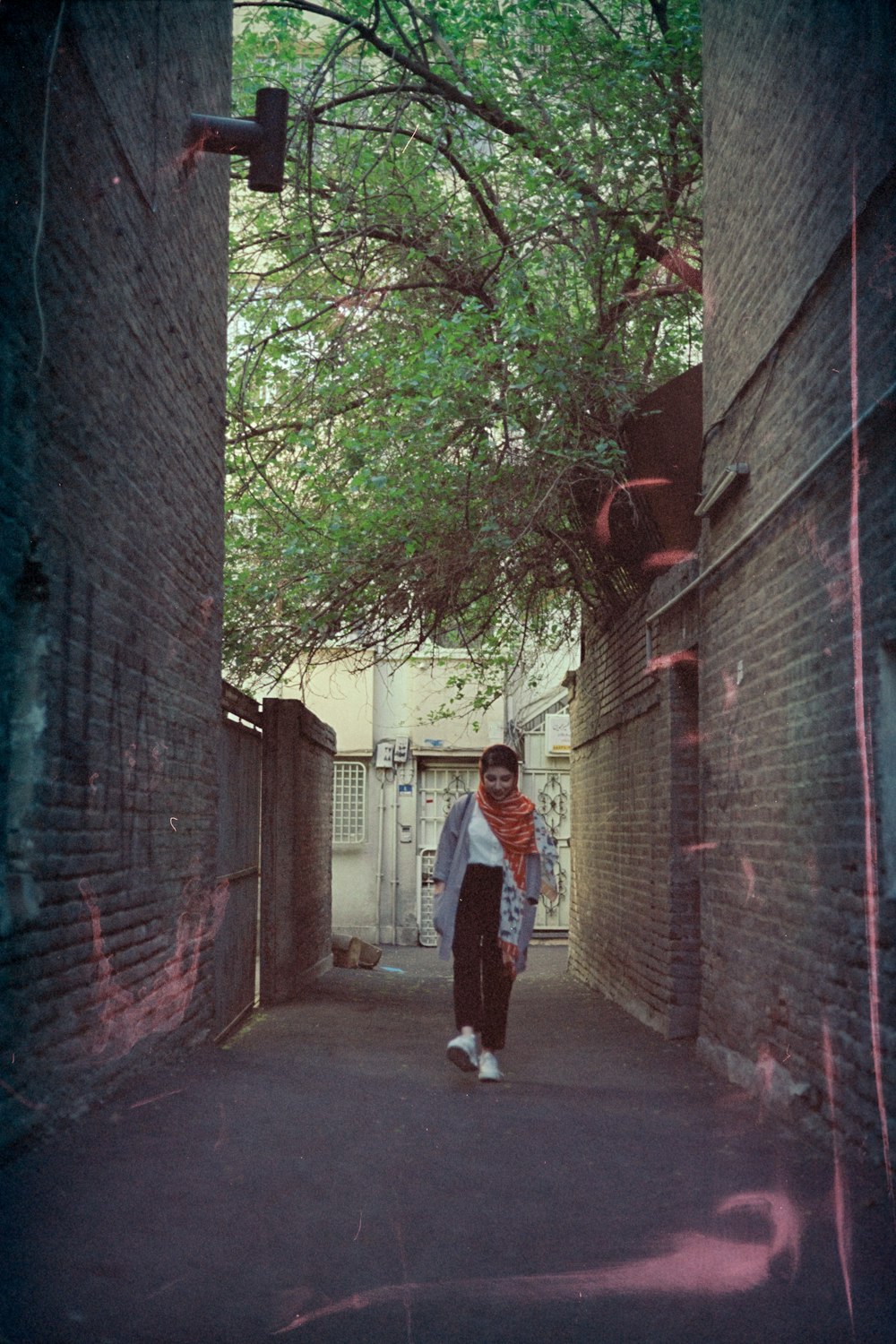 man in white shirt walking on sidewalk during daytime