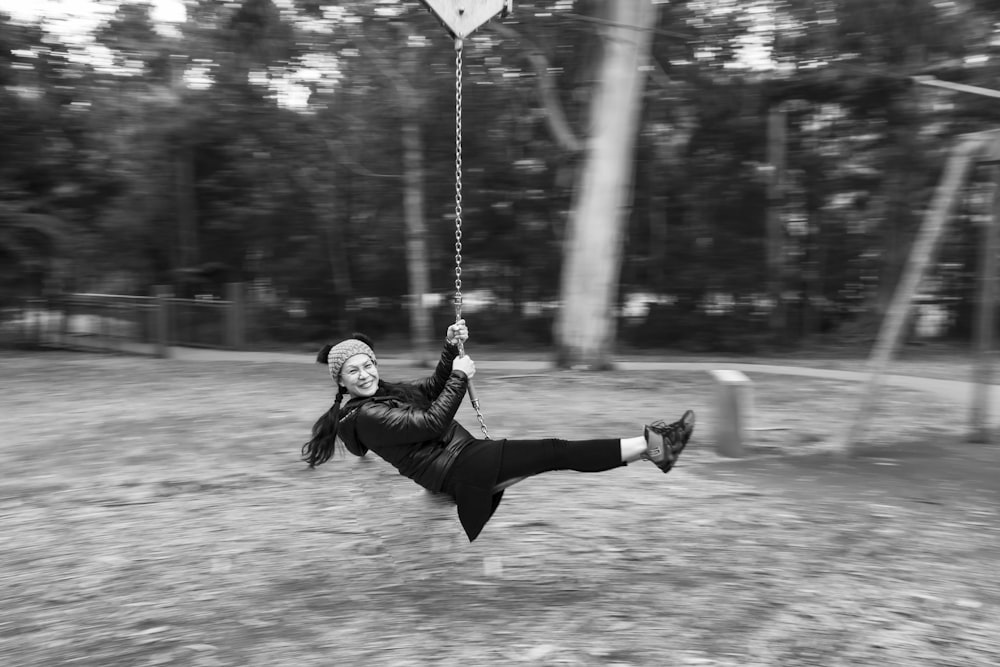 grayscale photo of woman in black jacket and pants playing with white umbrella