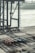 A large industrial shipping port with cranes towering over a wide area. Multiple cargo containers are neatly arranged on the ground, with some labeled with brand names. The background includes a body of water with large ships, contributing to a busy and industrious atmosphere.