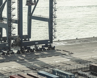 blue and red cargo containers near body of water during daytime