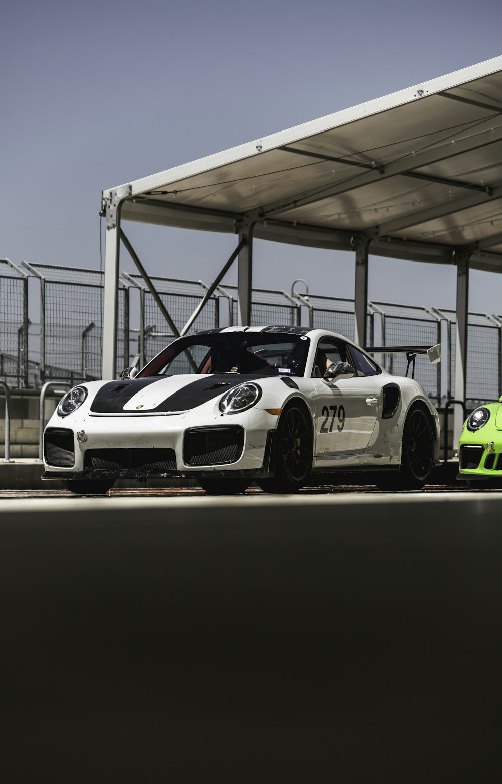 white and black porsche 911 parked in a parking lot