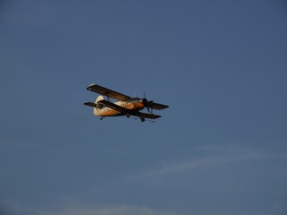 A vintage aircraft soaring through a clear blue sky.